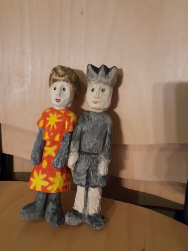 Holzfiguren für "Eine kurze Chronik des künftigen China" (Theater Lübeck) geschnitzte Holzfiguren; Frau in rot-gelbem Kleid, Mann mit kurzer Hose und Krone